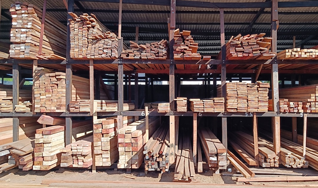 Stacks of dimension lumber stored on multi-level racks inside a lumber yard.